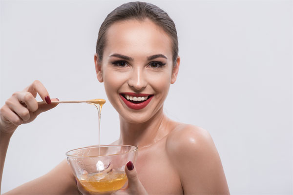girl with bowl of honey in nail studio